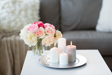 Image showing candles burning on table and flowers at cozy home