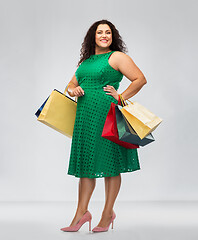 Image showing happy woman in green dress with shopping bags