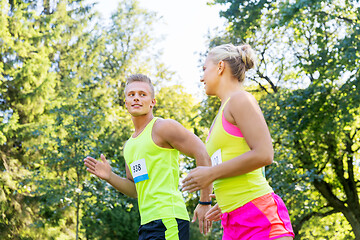 Image showing happy couple of sportsmen racing wit badge numbers