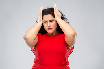 Image showing woman in red dress suffering from headache