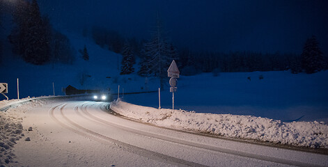 Image showing car driving on dangerous road at night on snow