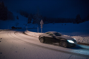 Image showing car driving on dangerous road at night on snow