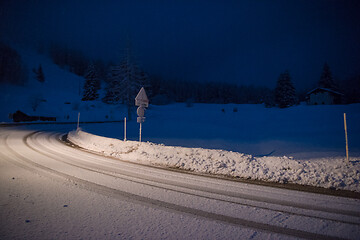 Image showing car driving on dangerous road at night on snow