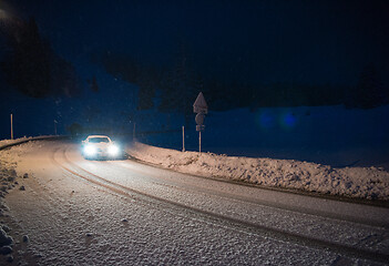 Image showing car driving on dangerous road at night on snow