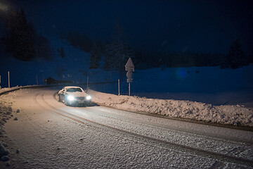 Image showing car driving on dangerous road at night on snow