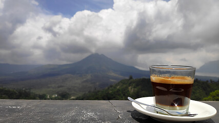 Image showing Mug with hot coffee with background of Batur volcano and lake