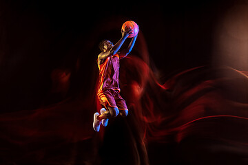 Image showing Young basketball player against dark background