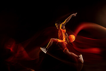 Image showing Young basketball player against dark background