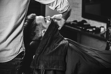 Image showing Client during beard shaving at barbershop.