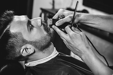 Image showing Client during beard shaving at barbershop.