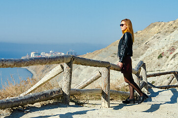 Image showing The girl examines the seascape from the mountain