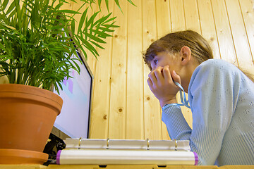 Image showing A student sits in front of the computer during distance learning and looks thoughtfully at the screen