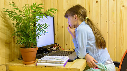 Image showing A schoolgirl thoughtfully reads a problem in an online lesson with distance learning