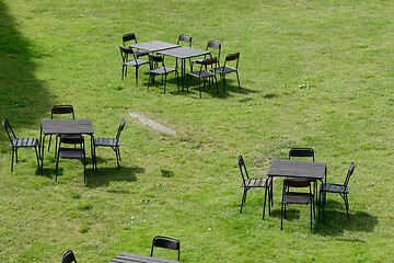 Image showing chairs and tables on a green lawn