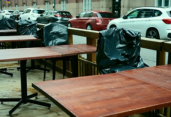 Image showing summer is over, plastic-covered chairs in empty street cafe