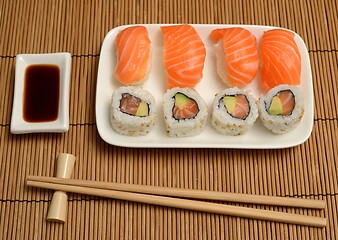Image showing chopsticks, soy sauce and sushi on the mat