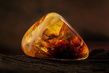 Image showing Beauty of natural raw amber. A piece of yellow-red transparent natural amber with inclusions in it.