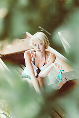 Image showing Woman relaxing on the vintage wooden boat.