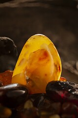 Image showing Beauty of natural amber. Big bright yellow natural amber stone in a cave.