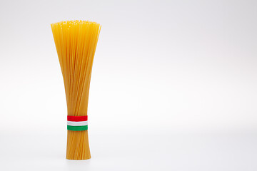 Image showing Bundle of spaghetti and Italian flag on the white table