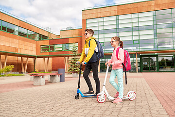 Image showing happy school children with backpacks and scooters