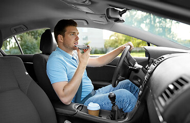 Image showing man driving car and recording voice by smartphone