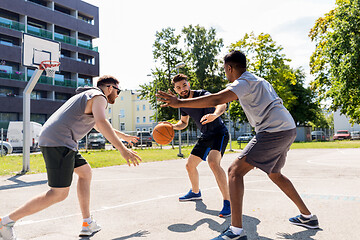 Image showing group of male friends playing street basketball