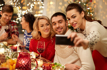 Image showing friends having christmas dinner and taking selfie