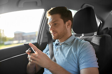 Image showing male passenger using smartphone in taxi car