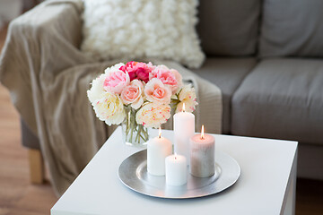 Image showing candles burning on table and flowers at cozy home