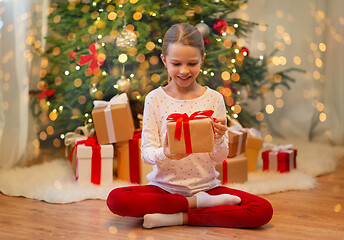 Image showing smiling girl with christmas gift at home