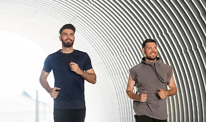 Image showing two happy young male friends running outdoors