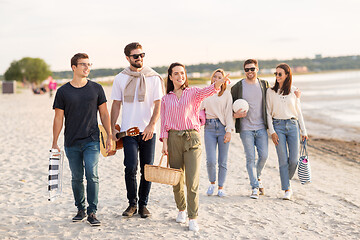 Image showing happy friends walking along summer beach