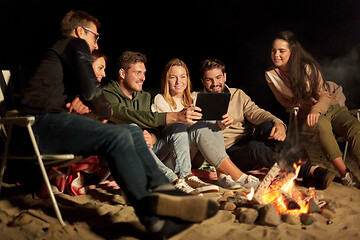 Image showing friends with tablet pc at night camp fire on beach