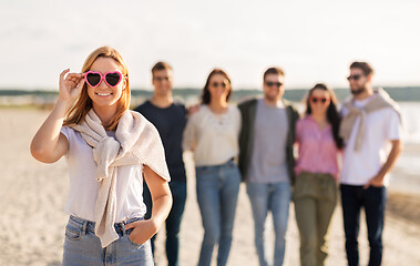 Image showing happy woman with friends on beach in summer