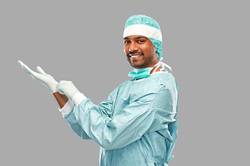 Image showing indian male doctor or surgeon putting glove on