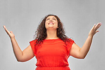 Image showing happy smiling woman in red dress looking up