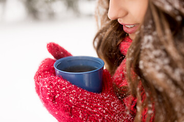 Image showing happy young woman with tea cup in winter park