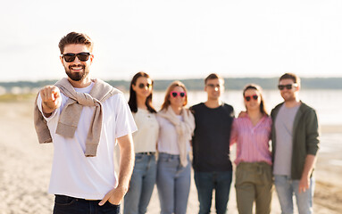 Image showing happy man with friends on beach in summer