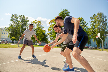 Image showing group of male friends playing street basketball