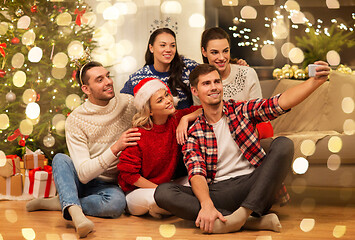 Image showing friends celebrating christmas and taking selfie