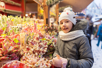 Image showing girl with lollipop at christmas market candy shop