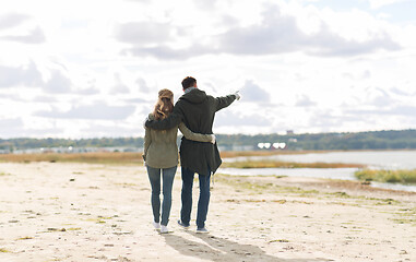 Image showing couple walking along autumn beach and hugging