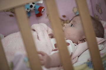 Image showing cute little baby playing with hands and smiling