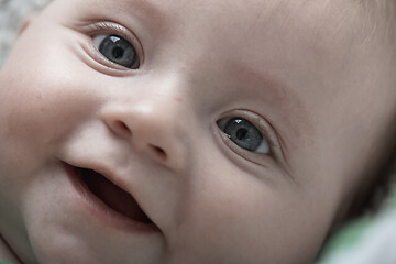 Image showing cute little baby playing with hands and smiling