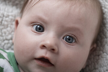 Image showing cute little baby playing with hands and smiling