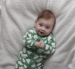 Image showing cute little baby playing with hands and smiling