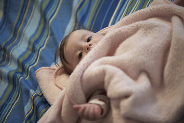 Image showing cute little baby playing with hands and smiling