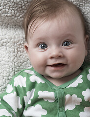 Image showing cute little baby playing with hands and smiling