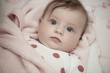 Image showing cute little baby playing with hands and smiling